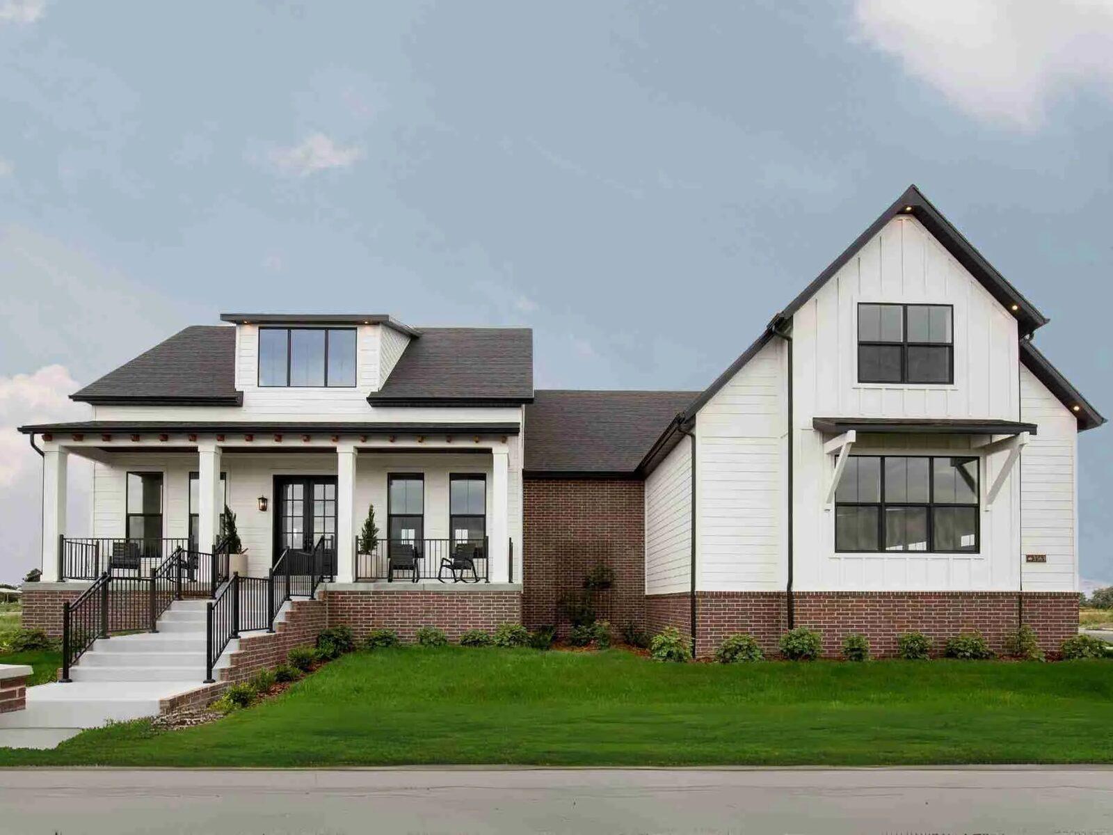 A completed production home with fresh foundation planting, sod, and a defined bed line