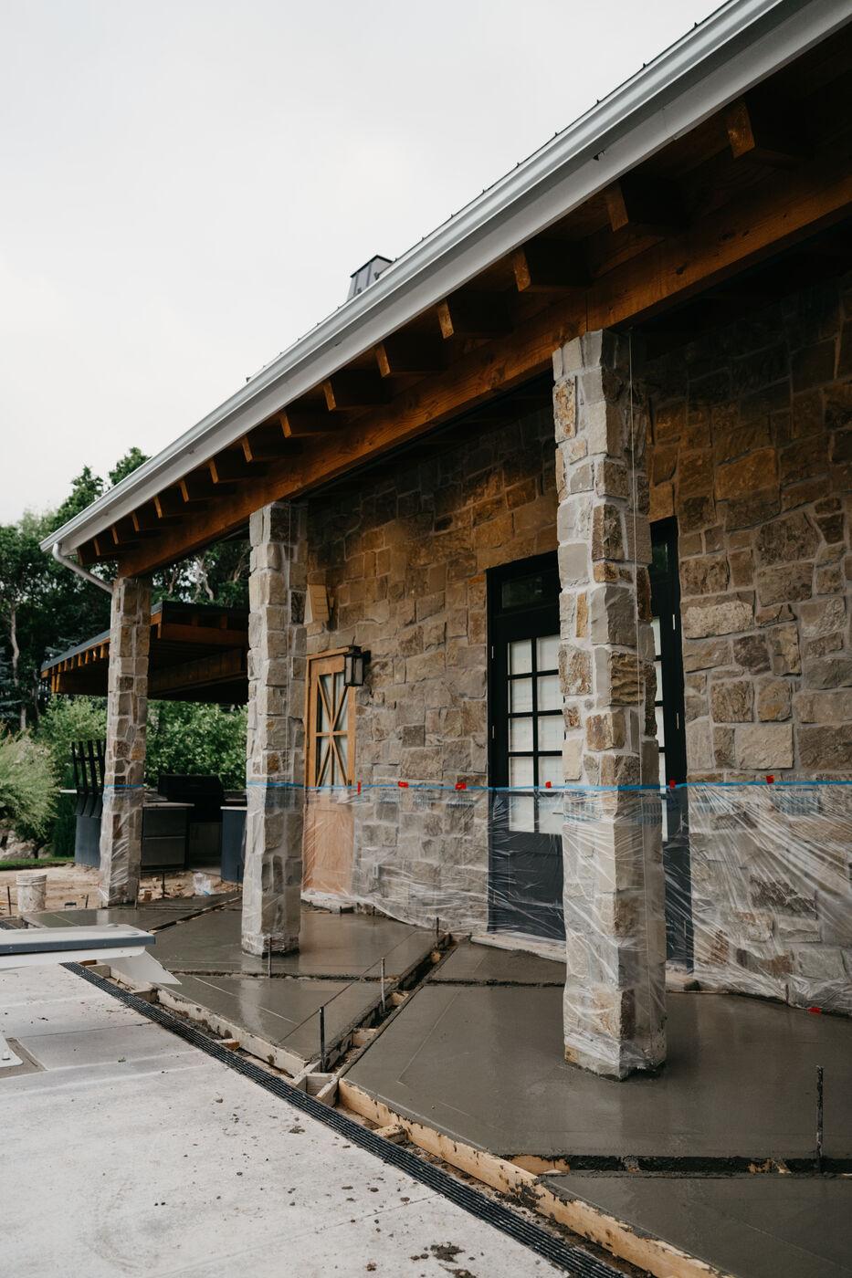 A wet slab poured to the base of a stone-and-timber pavilion
