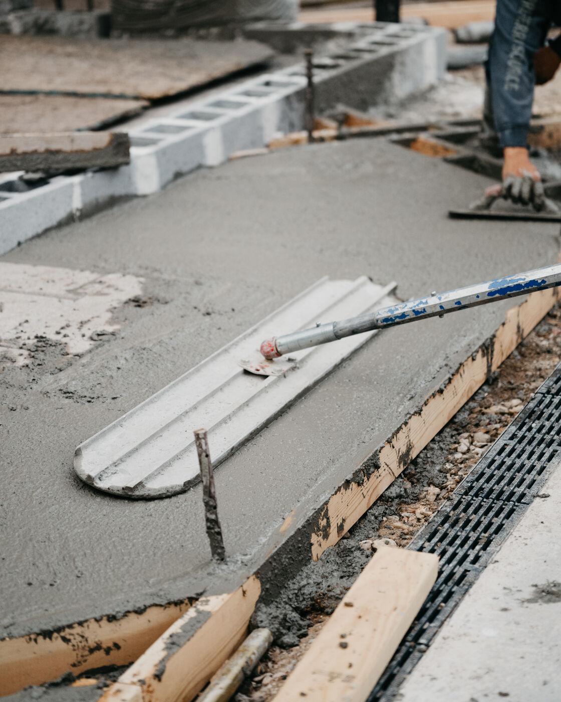 Screed rails and cut control joints on a slab still green