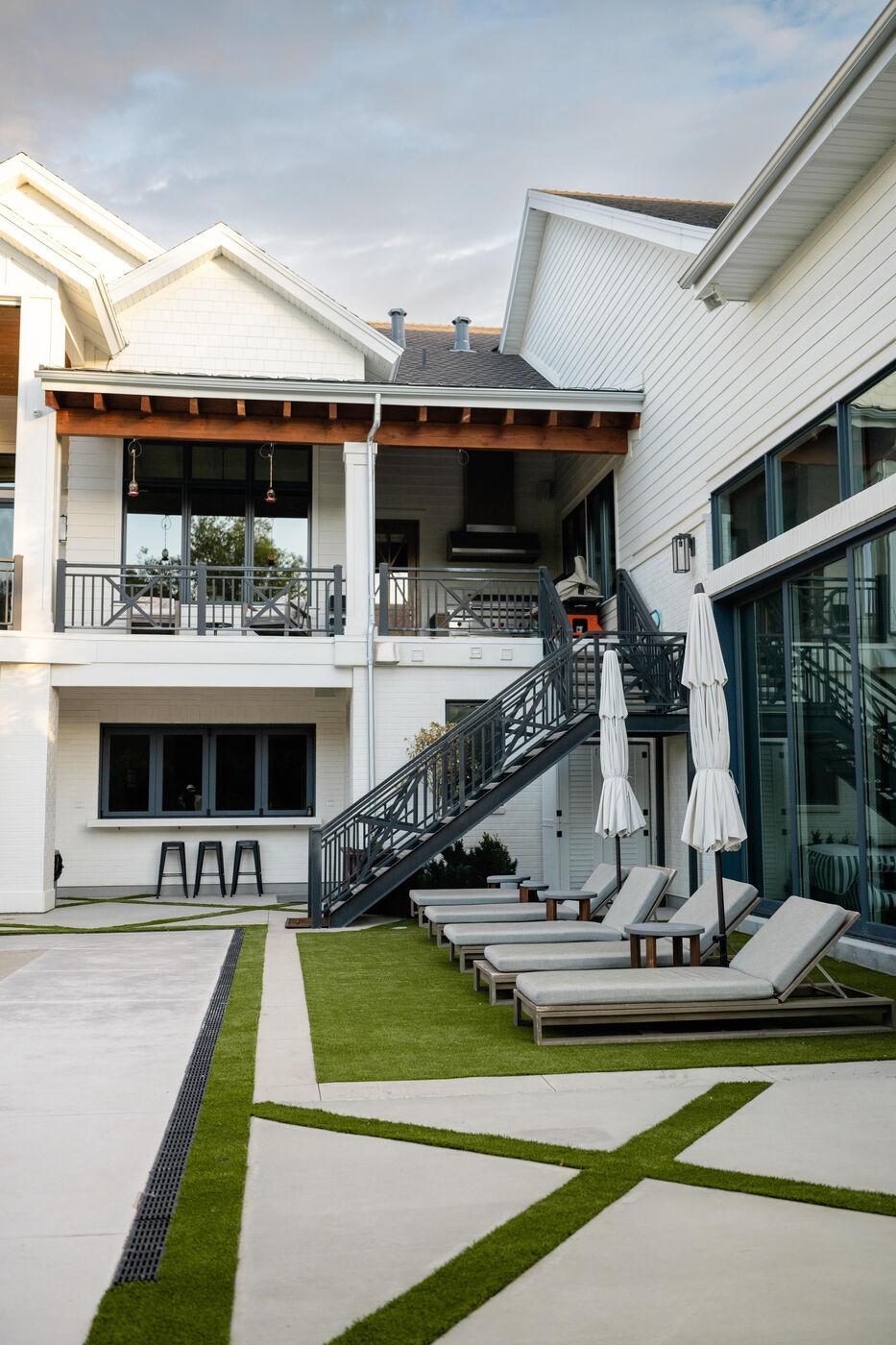 Paving set in turf joints running past loungers to the back of the house