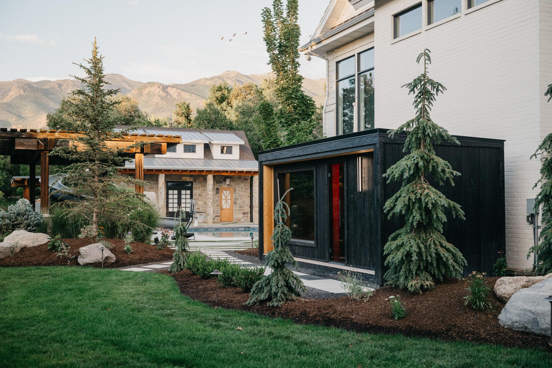 Lawn running to a timber pergola and the house, with mountains beyond