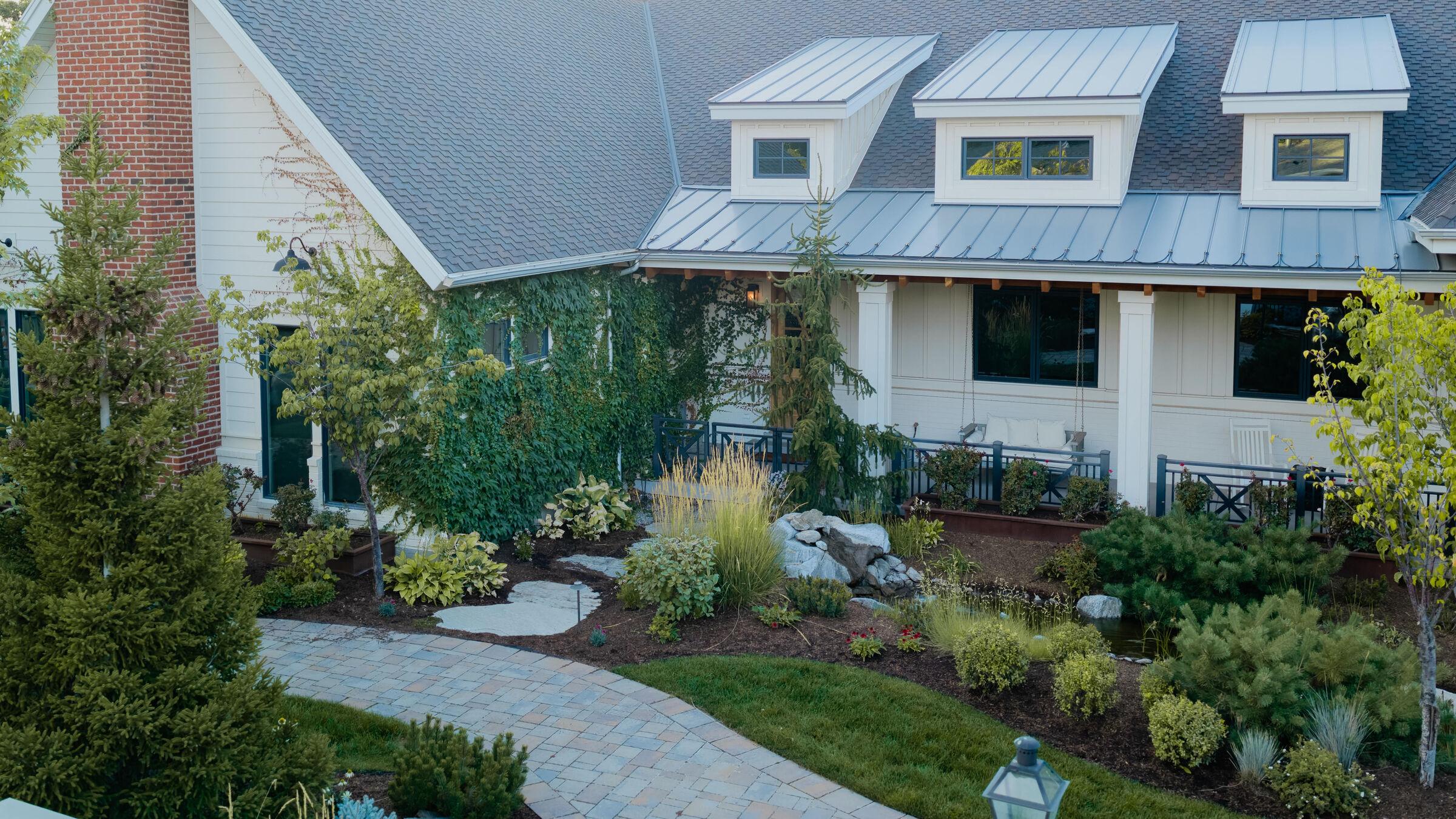 The house seen across its front planting and paver walk