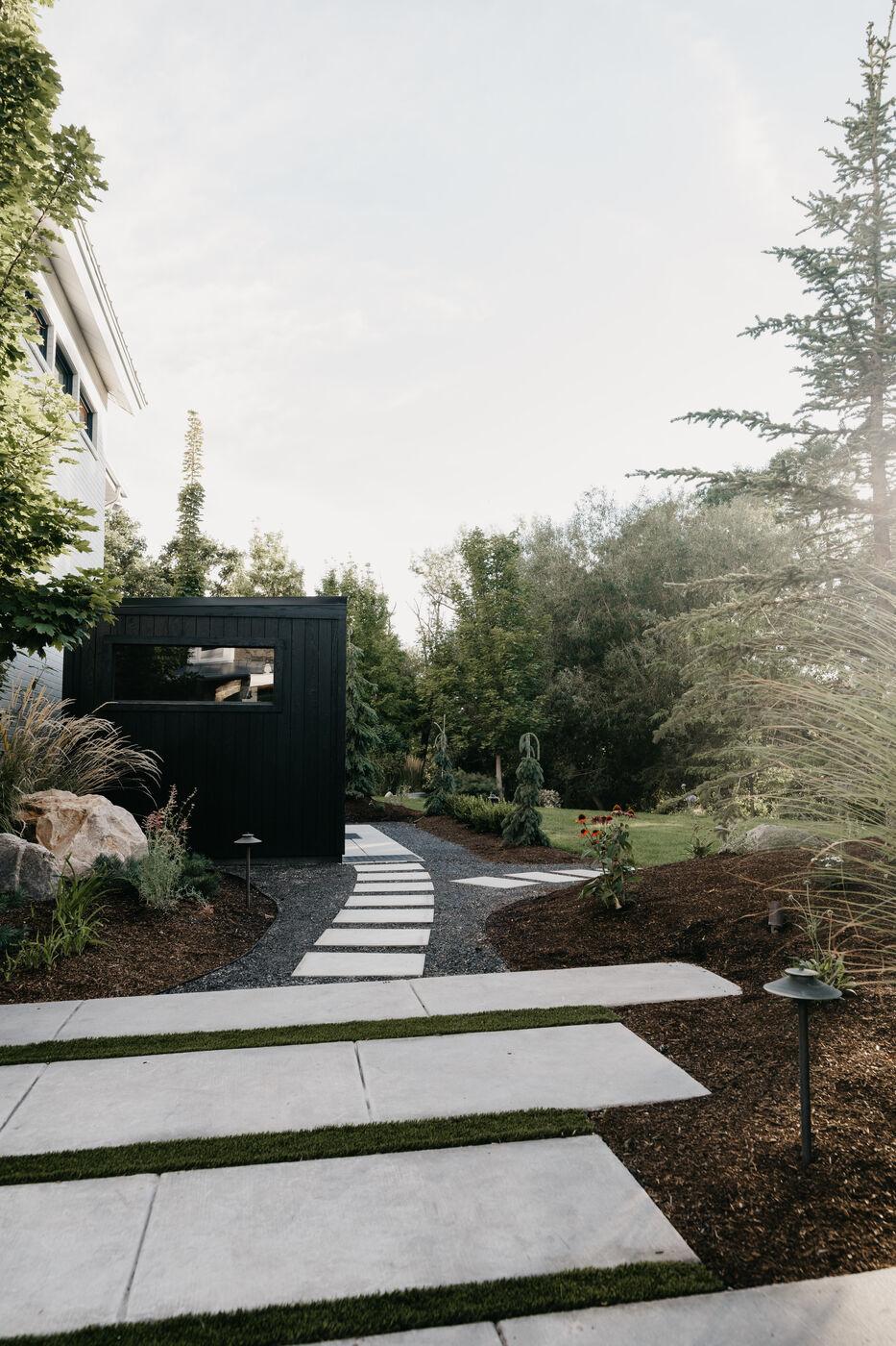 Large-format pavers set as stepping stones through mulch and low planting
