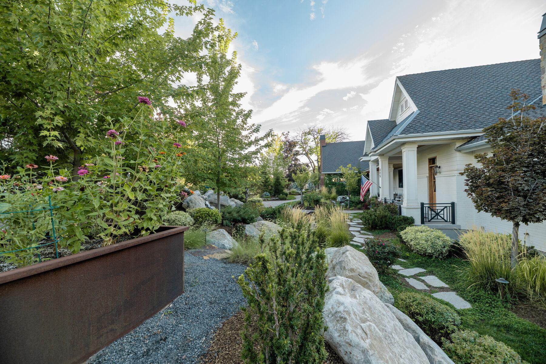 A corten planter and gravel margin running along the side of a house