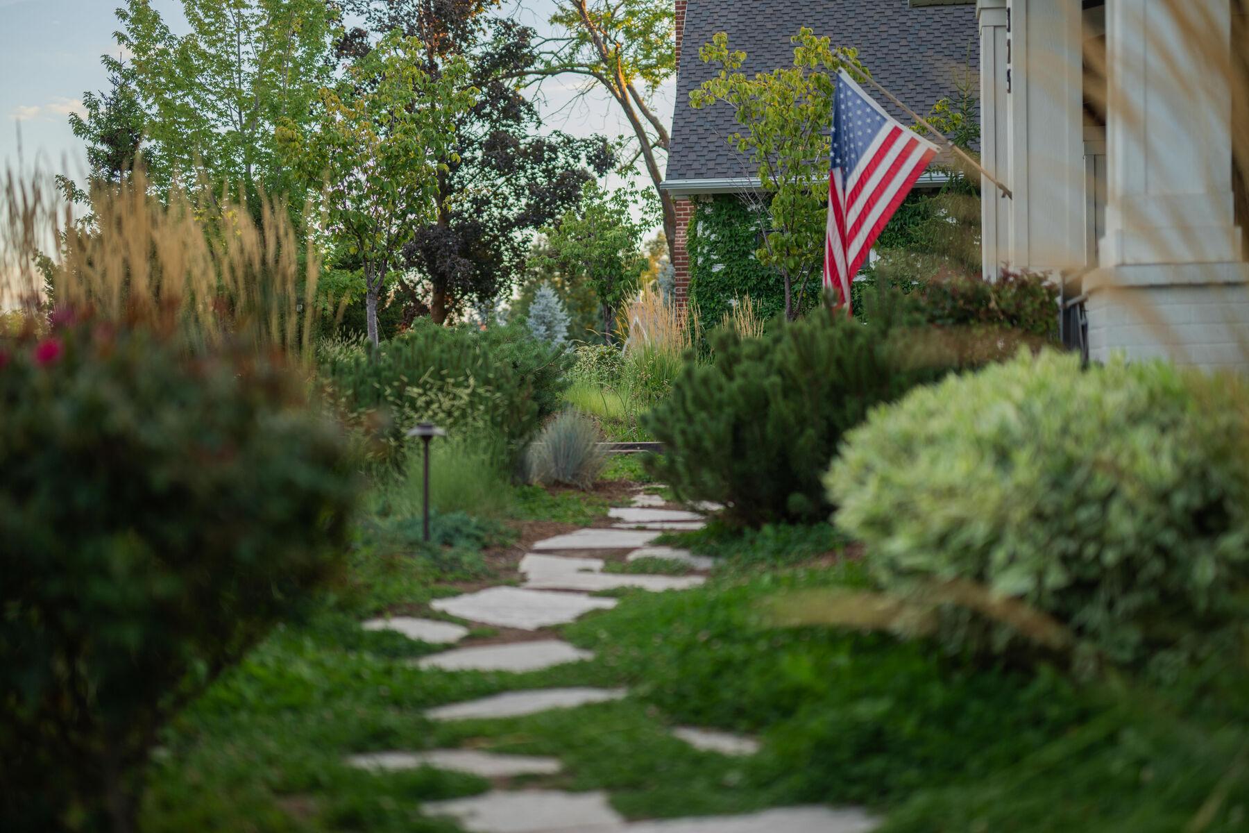 A flagstone path running through shrub planting toward the house