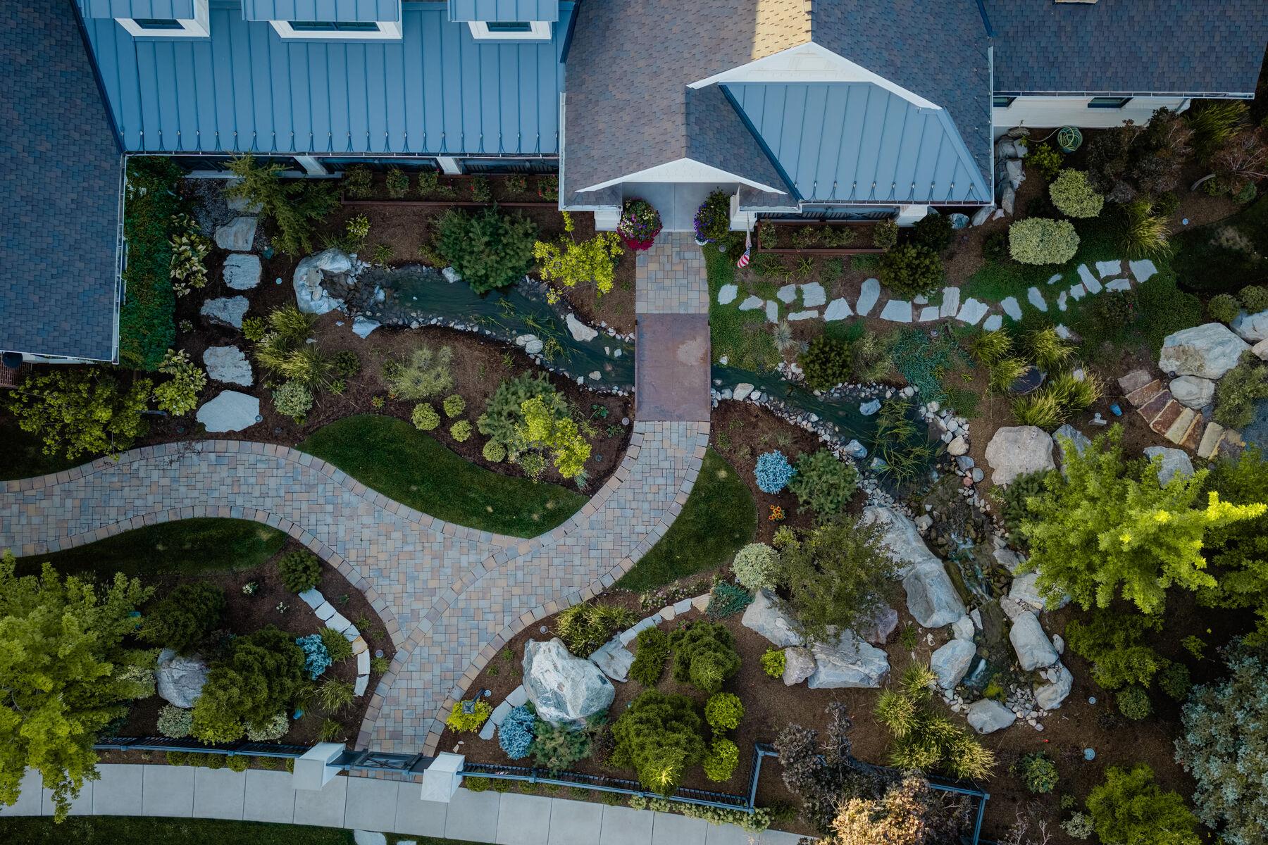 Overhead view of a stream threading a planted garden and passing beneath a walk